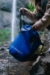Stansport 12 Liter Outdoor Trail Bucket with Lid zipped by person near water